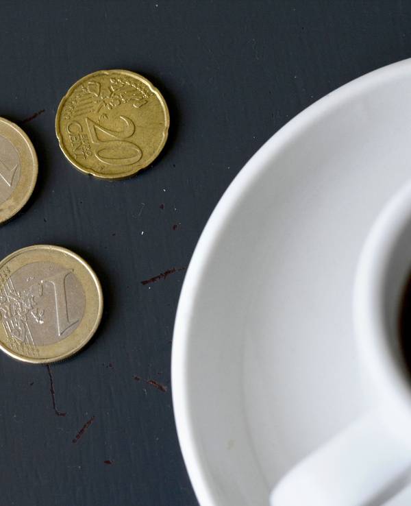 Trinkgeld liegt neben einer Tasse Kaffee auf dem Tisch, hier im Mai 2015 in Berlin.