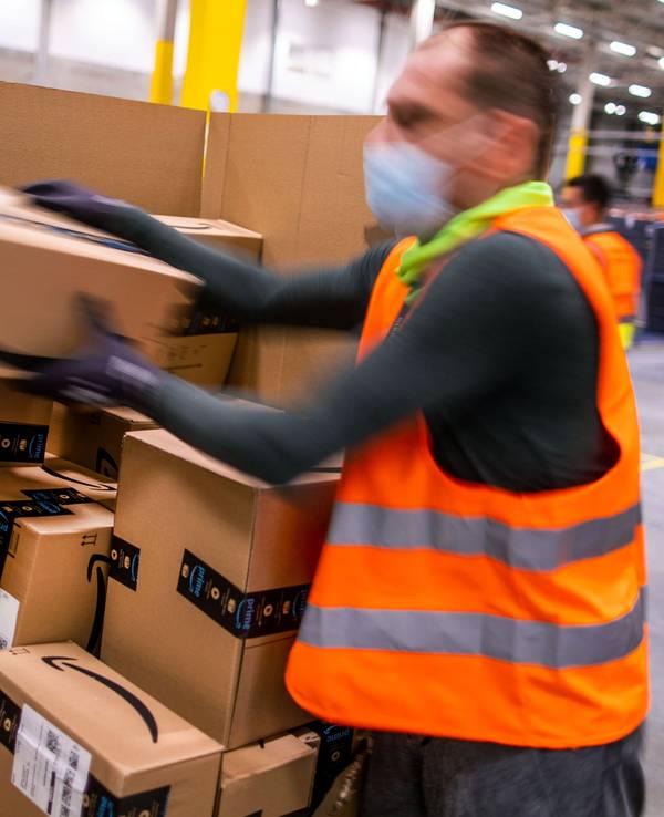 Ein Mitarbeiter sortiert an einem Transportband Paketsendungen in einem Verteilzentrum des Online-Händlers Amazon.