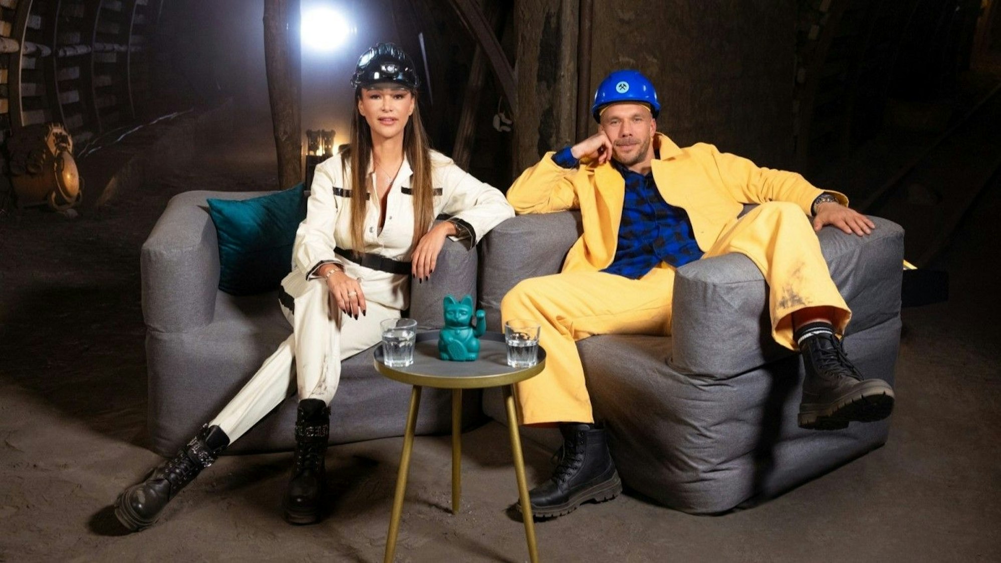 Verona Pooth und Lukas Podolski posieren in zwei Sesseln unter Tage.