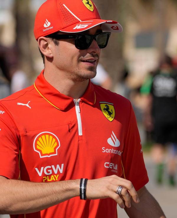 Charles Leclerc läuft im Ferrari-Outfit durch die Boxengasse.