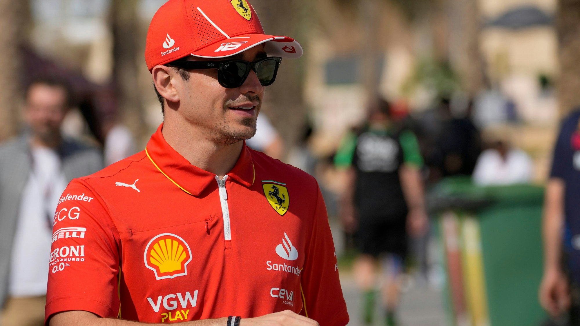 Charles Leclerc läuft im Ferrari-Outfit durch die Boxengasse.