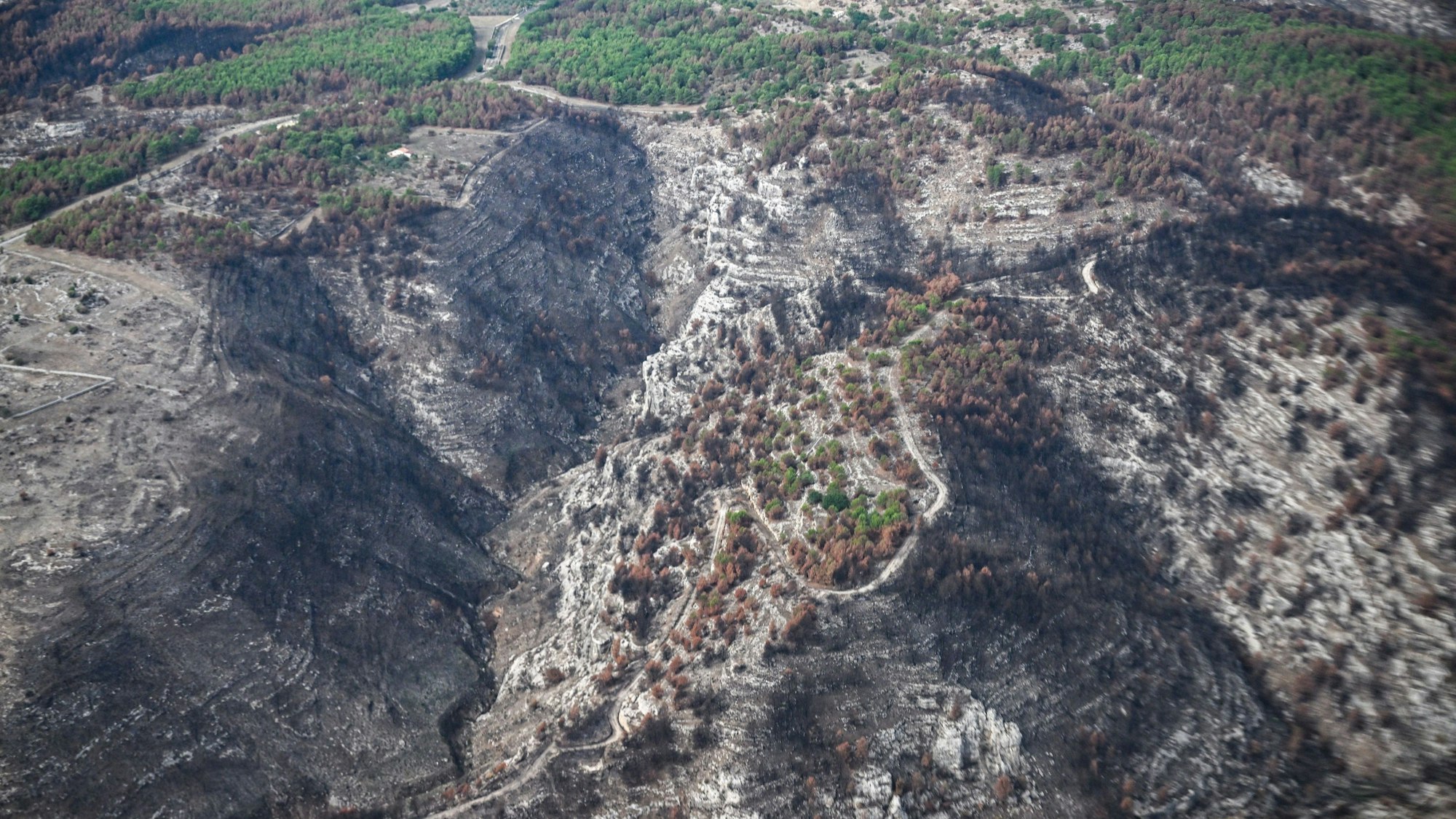 Die Aufnahmen aus einem Hubschrauber zeigen von den Waldbränden betroffene Gebiete.
