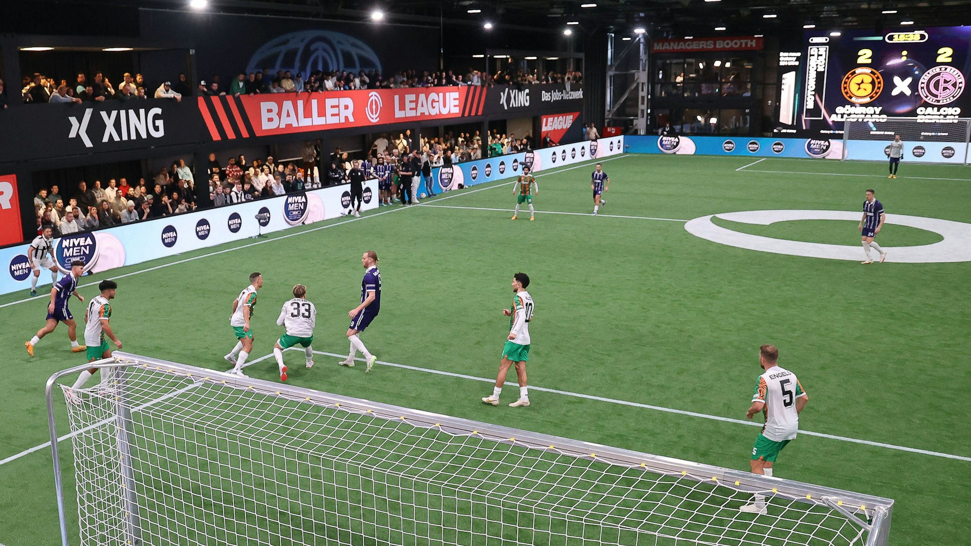 Zwei Teams spielen in der Baller League auf einem kleinen Hallenplatz gegeneinander.