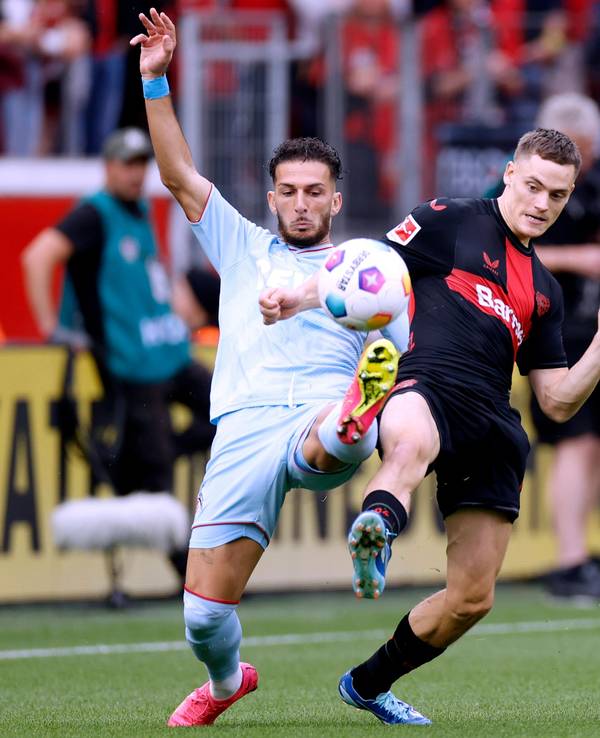 Leart Pacarada und Florian Wirtz beim Spiel zwischen Bayer Leverkusen und dem 1. FC Köln im Duell um den Ball.