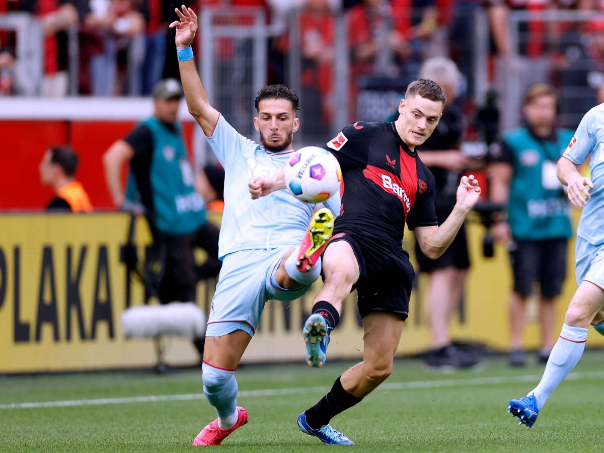 Leart Pacarada und Florian Wirtz beim Spiel zwischen Bayer Leverkusen und dem 1. FC Köln im Duell um den Ball.