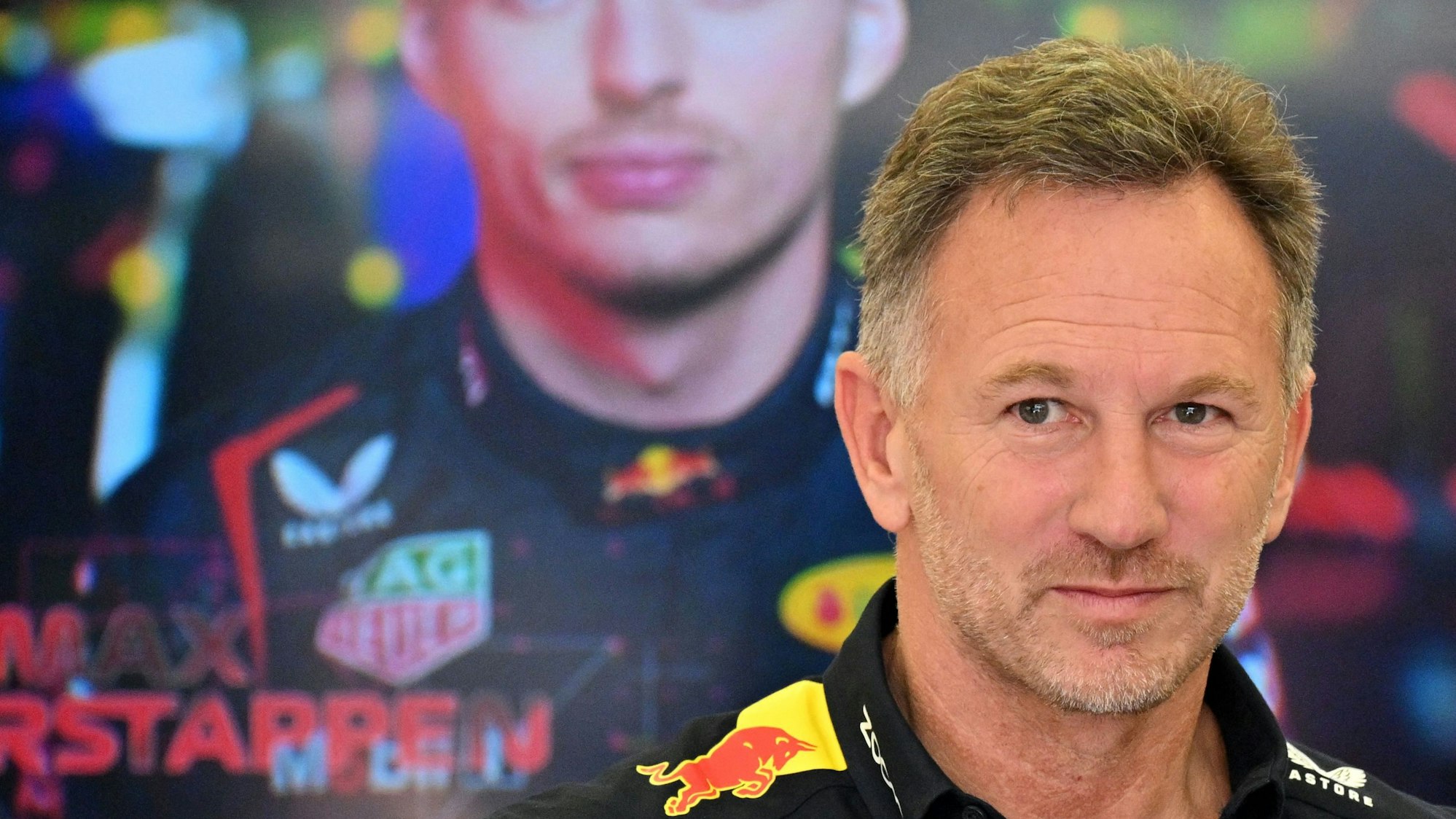 Christian Horner am 29. Februar 2024 in der Red-Bull-Garage in Bahrain vor einem Bild von Max Verstappen.
