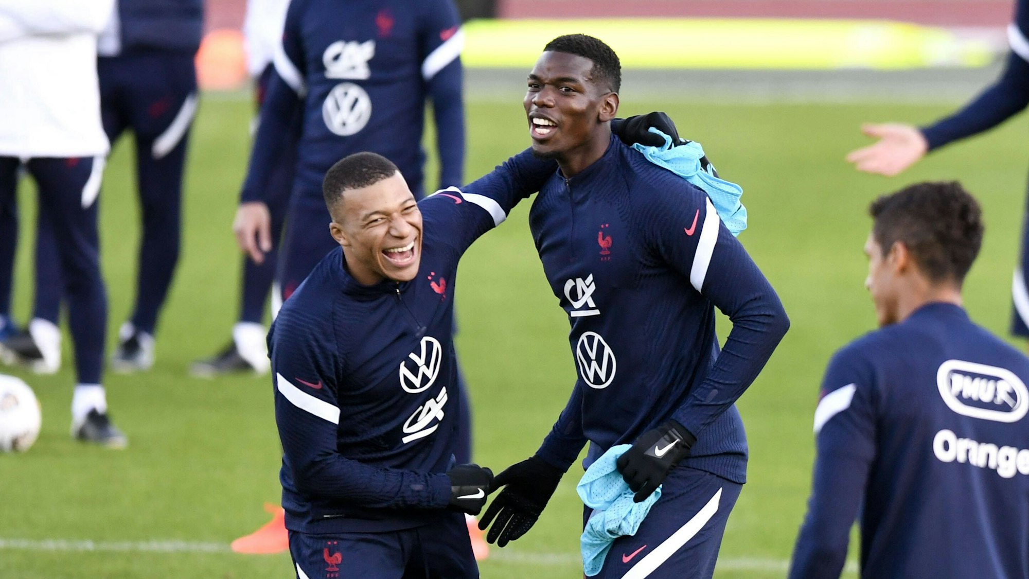 Paul Pogba lacht mit seinem Nationalmannschaftskollegen Kylian Mbappe.