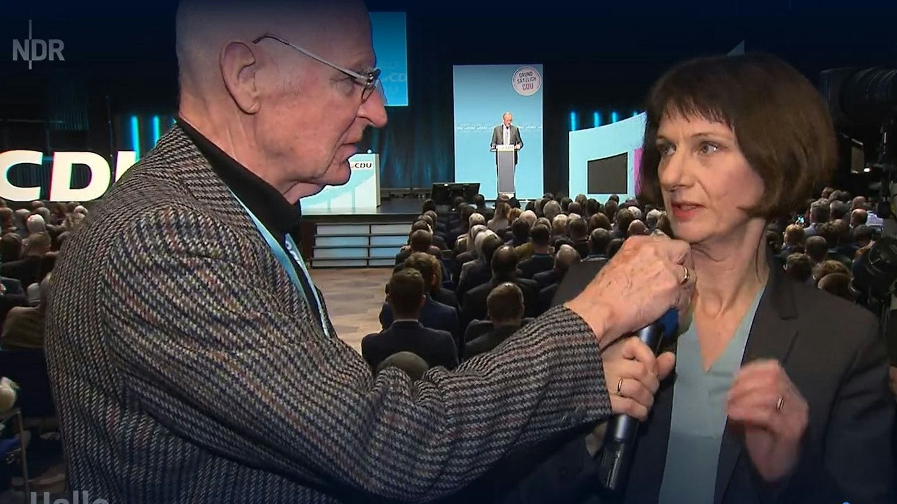 Bei einer CDU-Regionalkonferenz greift ein Mann NDR-Reporterin Katharina Seiler ins Mikrofon.