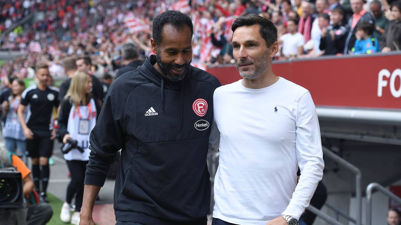 Fortuna Düsseldorfs Trainer Daniel Thioune und Hannover-Coach Stefan Leitl anehmen sich am Spielfeldrand in den Arm.
