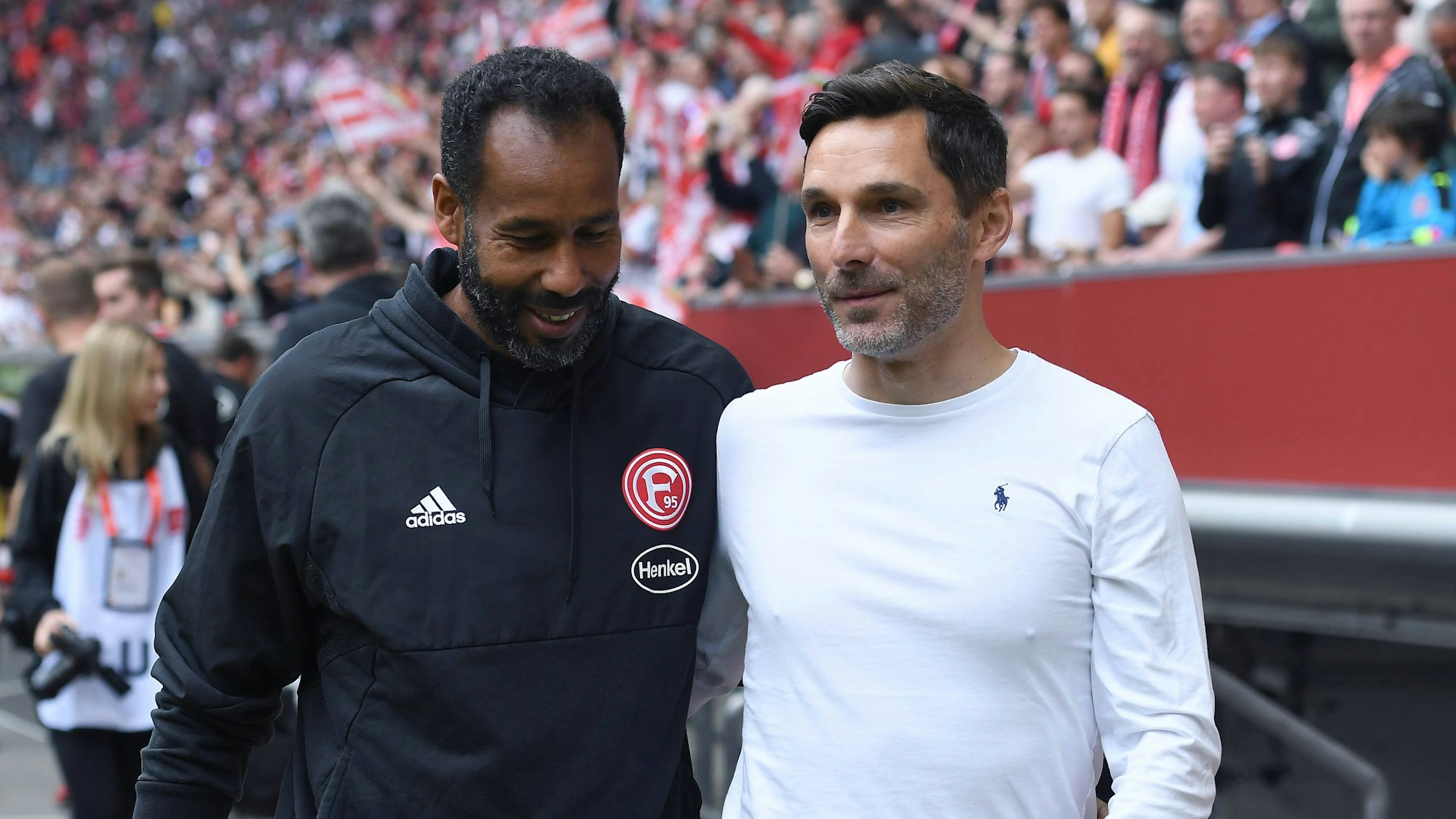Fortuna Düsseldorfs Trainer Daniel Thioune und Hannover-Coach Stefan Leitl anehmen sich am Spielfeldrand in den Arm.