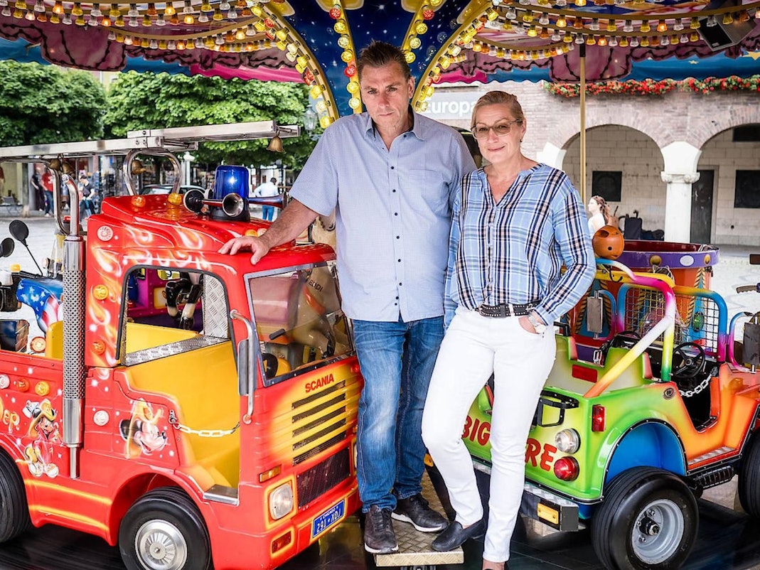 Wilfried Hoffmann steht mit seiner Frau in einem seiner Karussells.