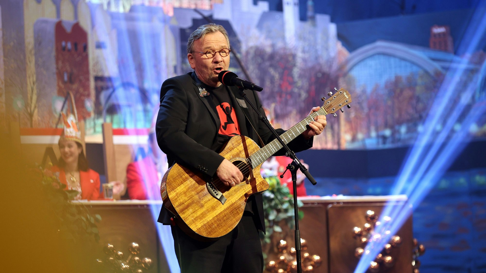 Bernd Stelter mit Gitarre auf der Bühne bei einer Karnevalssitzung.