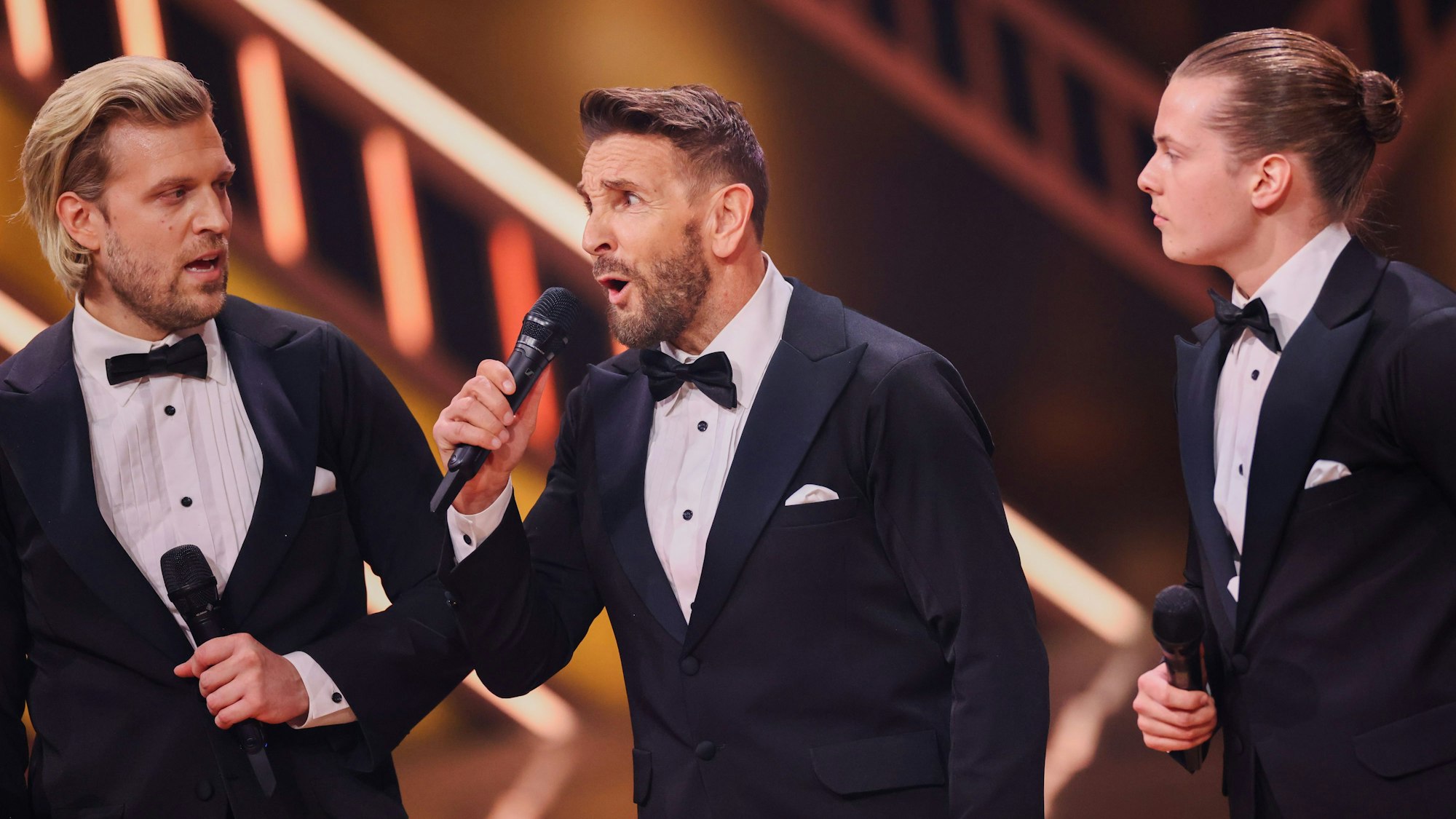 Tillman Schulz, Mark Keller, und Gabriel Kelly stehen auf dem Tanzparkett.