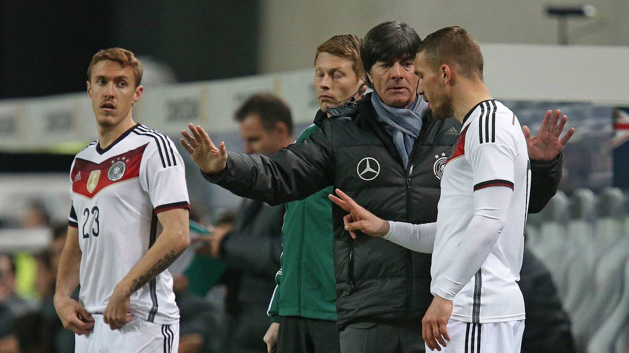Lukas Podolski erhält vor seiner Einwechslung von Joachim Löw letzte Anweisungen. Max Kruse schaut interessiert zu.