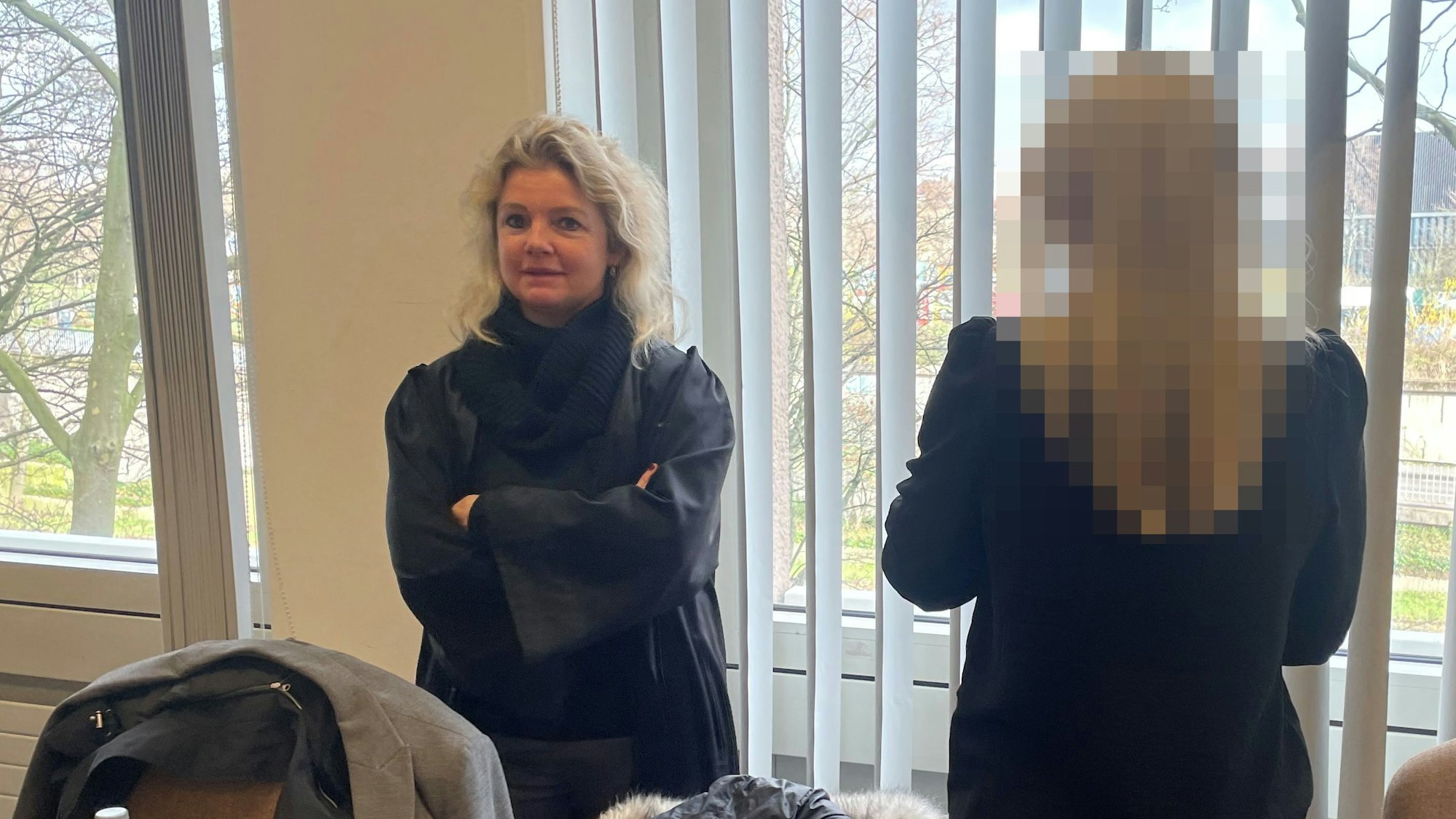 Zwei Frauen stehen im Gerichtssaal.