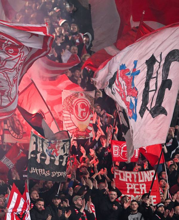 Die Fans von Fortuna Düsseldorf schwenken beim Auswärtsspiel gegen Hannover 96 ihre Fahnen.