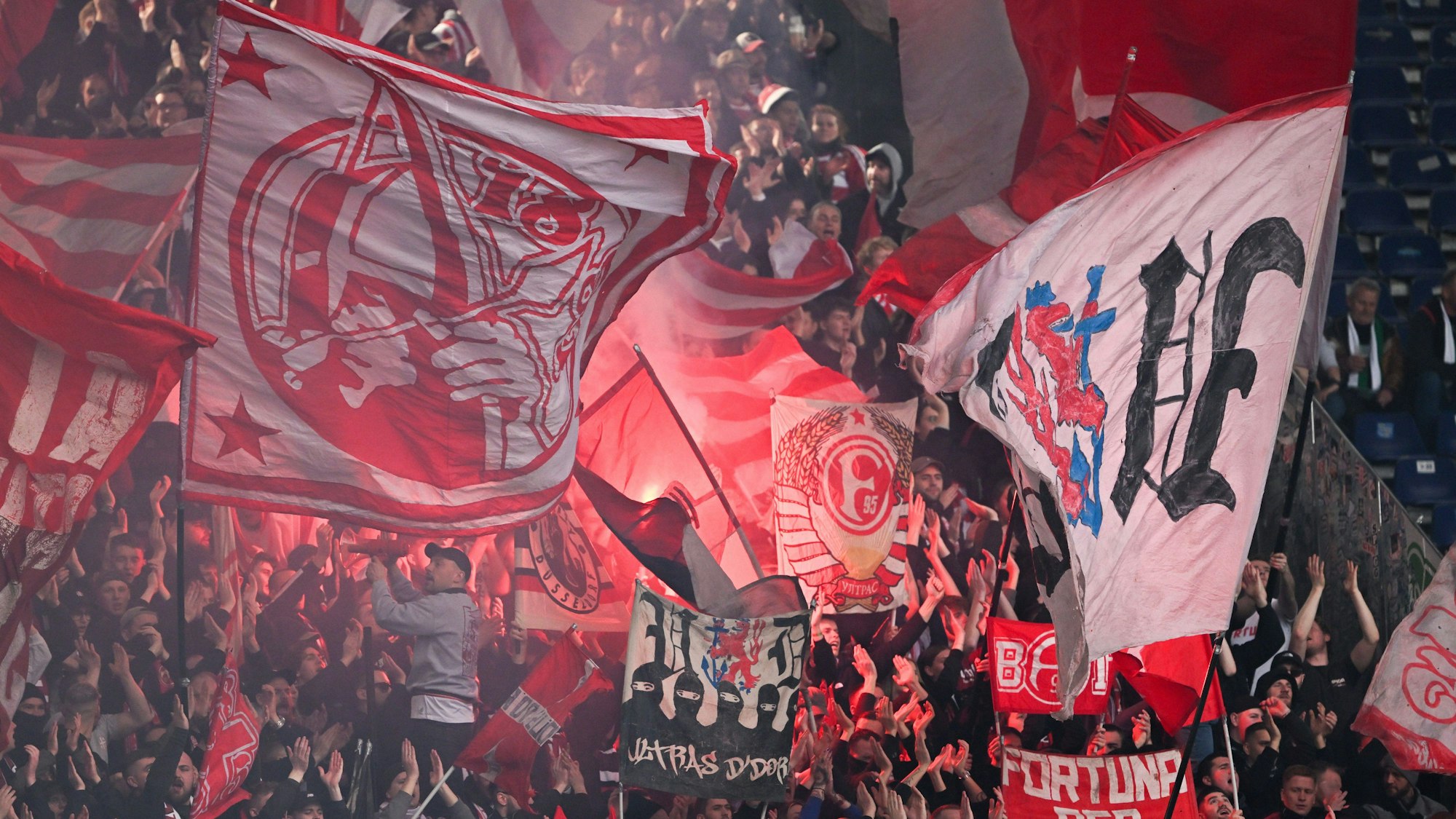 Die Fans von Fortuna Düsseldorf schwenken beim Auswärtsspiel gegen Hannover 96 ihre Fahnen.