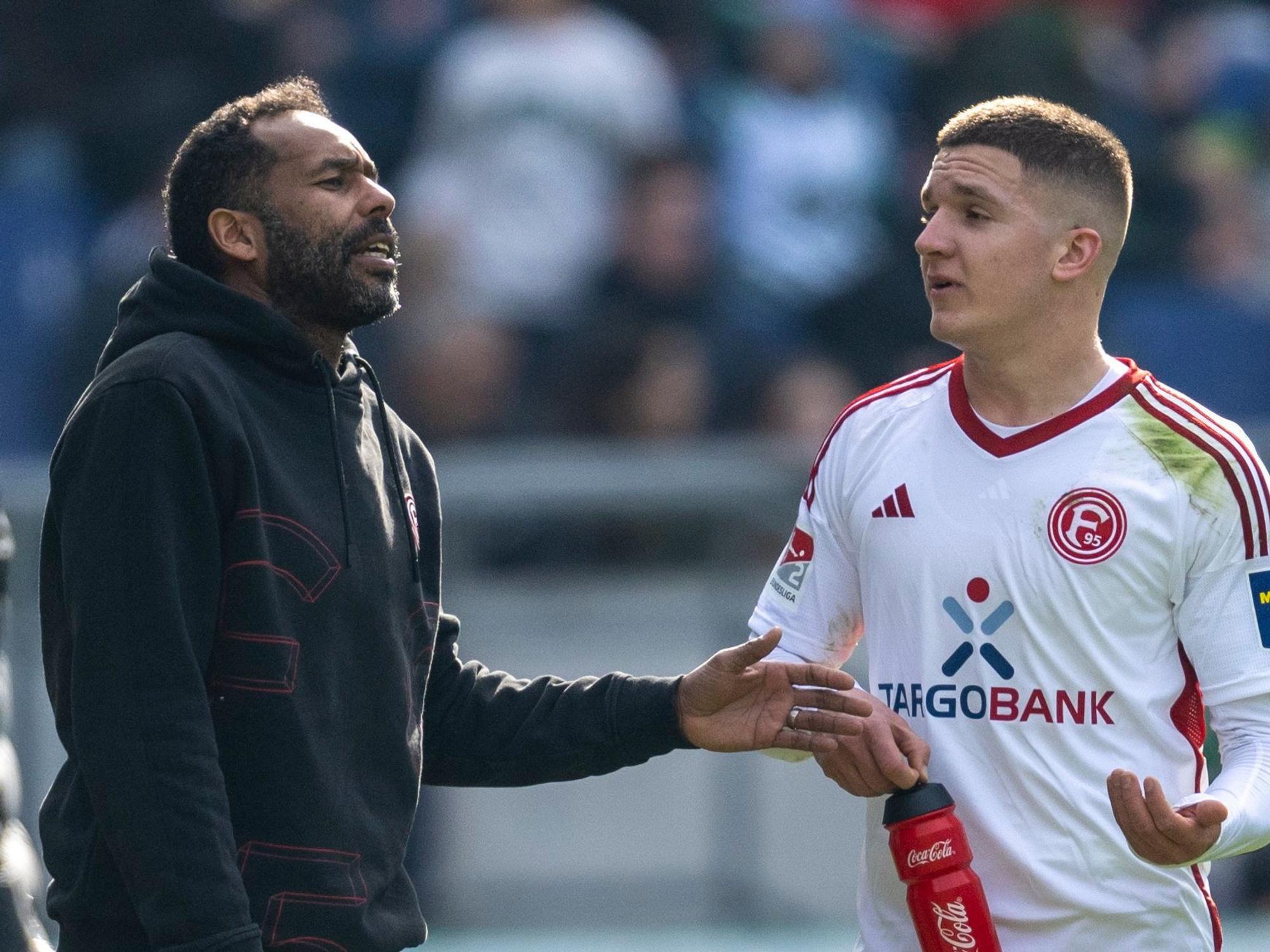 Düsseldorfs Trainer Daniel Thioune (l.) spricht am 2. März 2024 mit Fortuna-Profi Christos Tzolis.