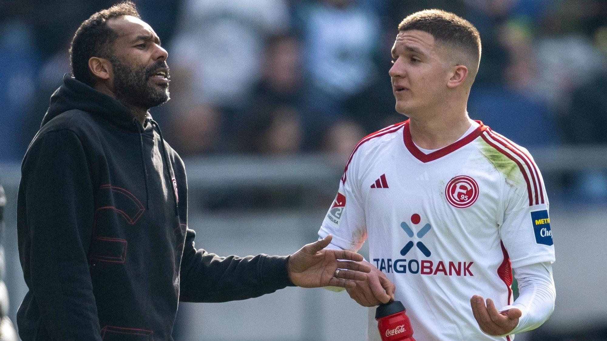 Fortuna-Trainer Daniel Thioune gestikuliert im Gespräch mit Christos Tzolis.
