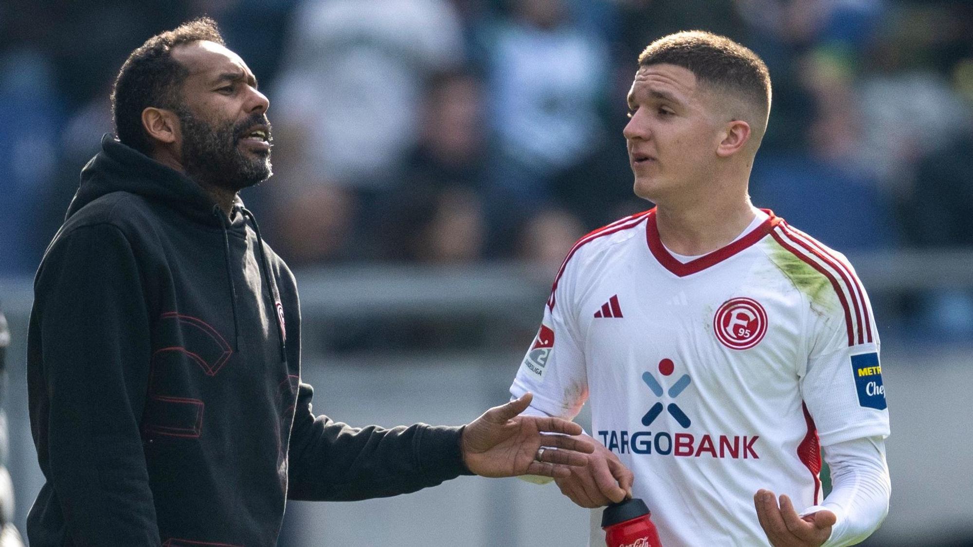 Fortuna Düsseldorfs Trainer Daniel Thioune und Doppeltorschütze Christos Tzolis sprechen auf dem Platz.