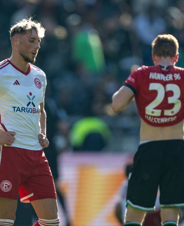 Fortuna Düsseldorfs Jona Niemiec steht nach dem Schlusspfiff in Hannover enttäuscht auf dem Rasen.