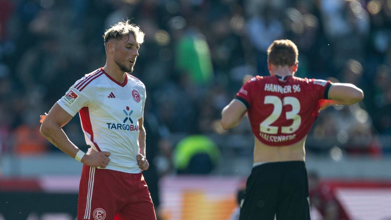 Fortuna Düsseldorfs Jona Niemiec steht nach dem Schlusspfiff in Hannover enttäuscht auf dem Rasen.