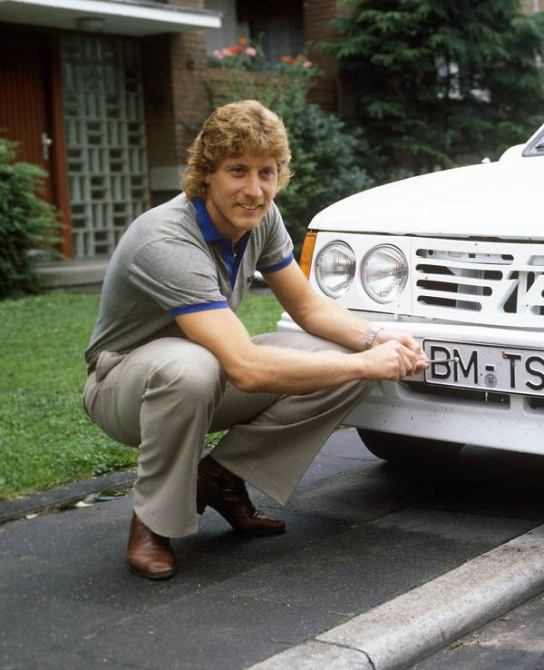 Torwart Harald Schumacher 1. FC Köln schraubt am Nummernschild seines Opel Kadett.