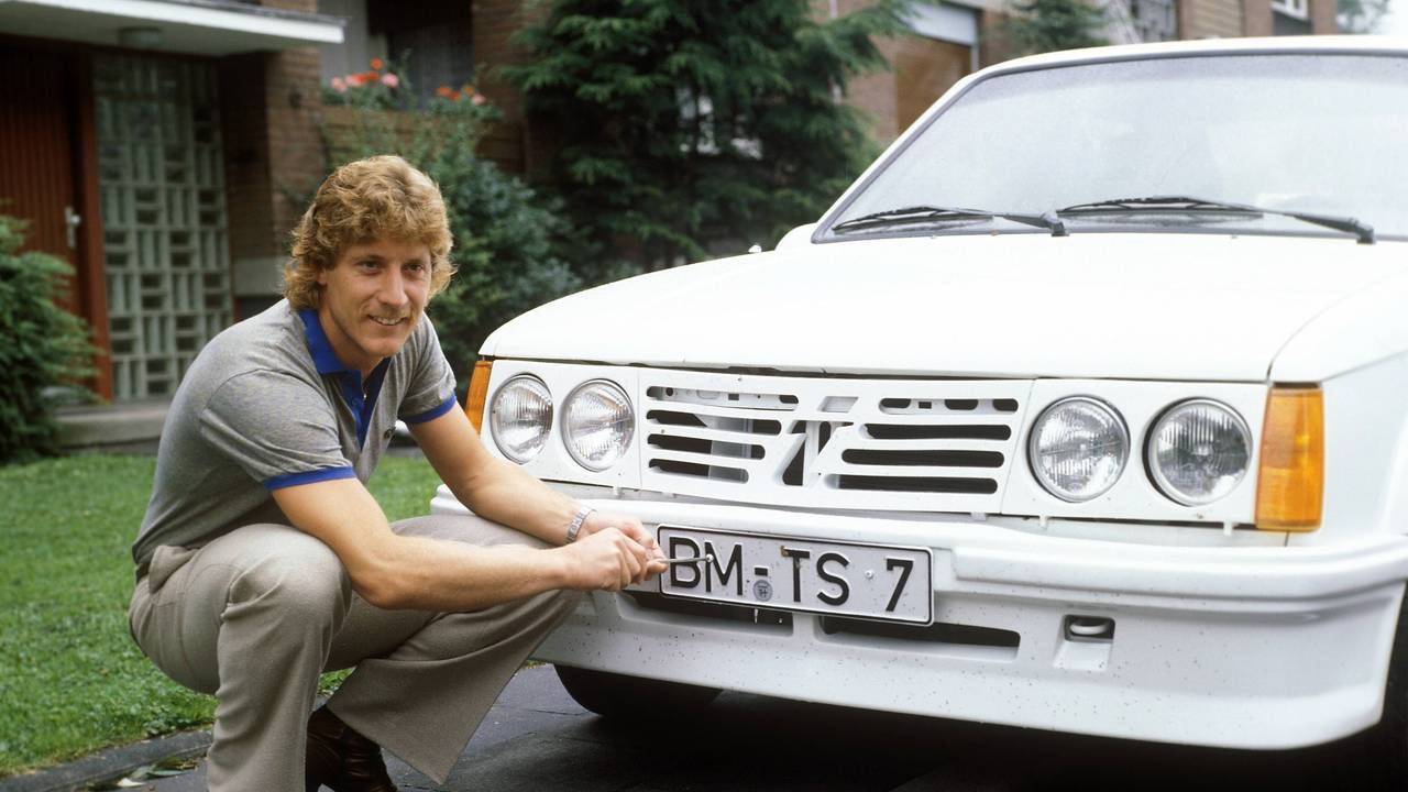 Torwart Harald Schumacher 1. FC Köln schraubt am Nummernschild seines Opel Kadett.