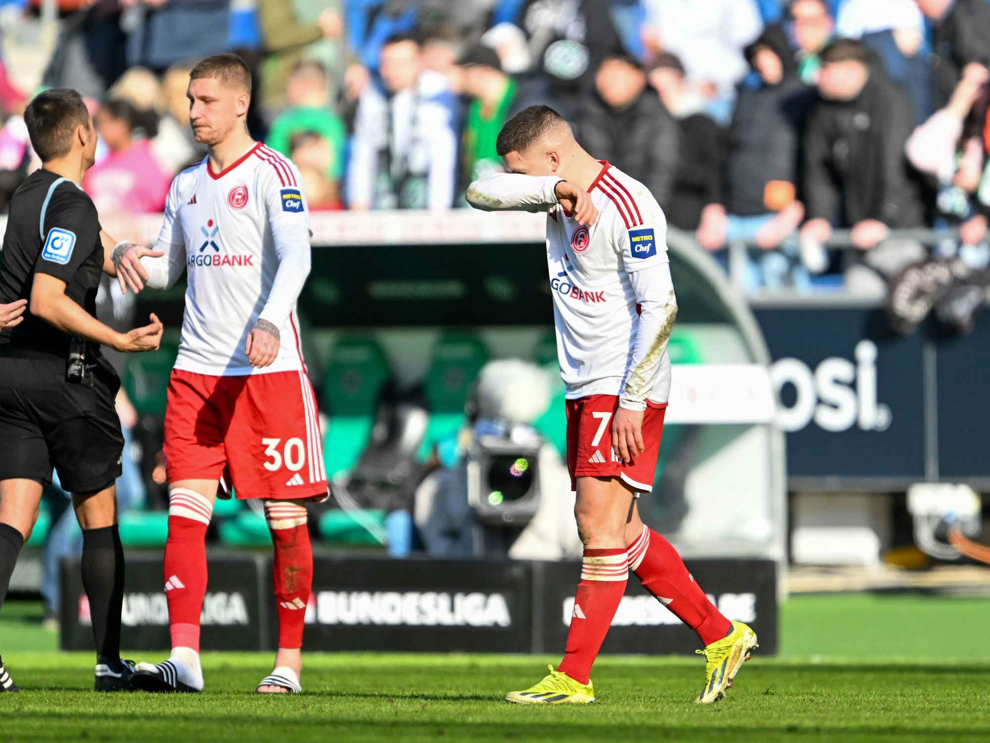 Yannik Engelhardt schleicht nach dem 2:2 in Hannover enttäuscht vom Platz, Jordy de Wijs trägt nach seiner Auswechslung bereits Badelatschen.