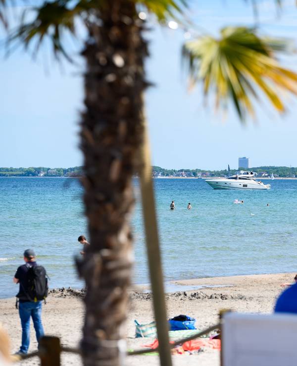 Eine Motoryacht ist auf der Ostsee vor der Beachlounge Scharbeutz. Seit einigen Jahren breitet sich an den Ostseestränden ein neuer Trend aus. Strandbars bieten ihren Gästen kühle Getränke, bunte Cocktails und leckere Speisen an. Und ein unbeschwertes Urlaubsgefühl mit den Füßen im Sand.