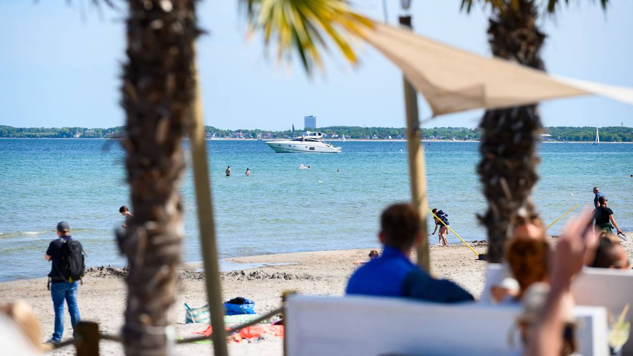 Eine Motoryacht ist auf der Ostsee vor der Beachlounge Scharbeutz. Seit einigen Jahren breitet sich an den Ostseestränden ein neuer Trend aus. Strandbars bieten ihren Gästen kühle Getränke, bunte Cocktails und leckere Speisen an. Und ein unbeschwertes Urlaubsgefühl mit den Füßen im Sand.