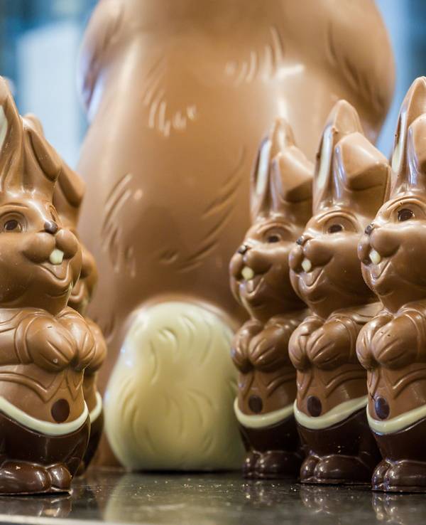 Lachende Osterhasen aus Schokolade stehen auf einem Tisch. Das Foto wurde 2021 in Brandenburg aufgenommen.