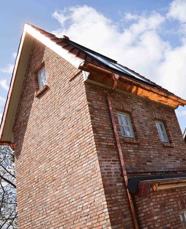 Ein ehemaliges Trafohäuschen (links) und weitere restaurierte oder im historischen Stil gebaute Hotel-Häuschen stehen neben dem Wasserturm am Kalkberg in Bad Segeberg.