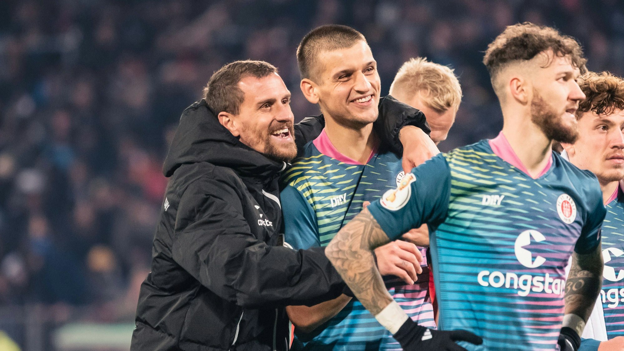 Simon Zoller (l.) feiert mit seinen Mitspielern den Sieg des FC St. Pauli im DFB-Pokal-Spiel gegen Schalke.