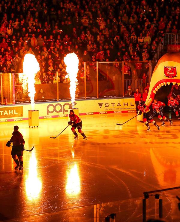 Die Mannschaft der Kölner Haie läuft durch einen aufgeblasenen Haikopf in die LANXESS Arena ein.