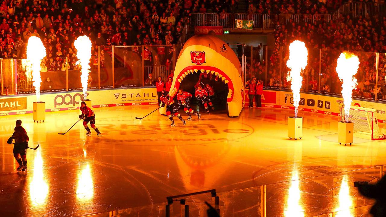 Die Mannschaft der Kölner Haie läuft durch einen aufgeblasenen Haikopf in die LANXESS Arena ein.