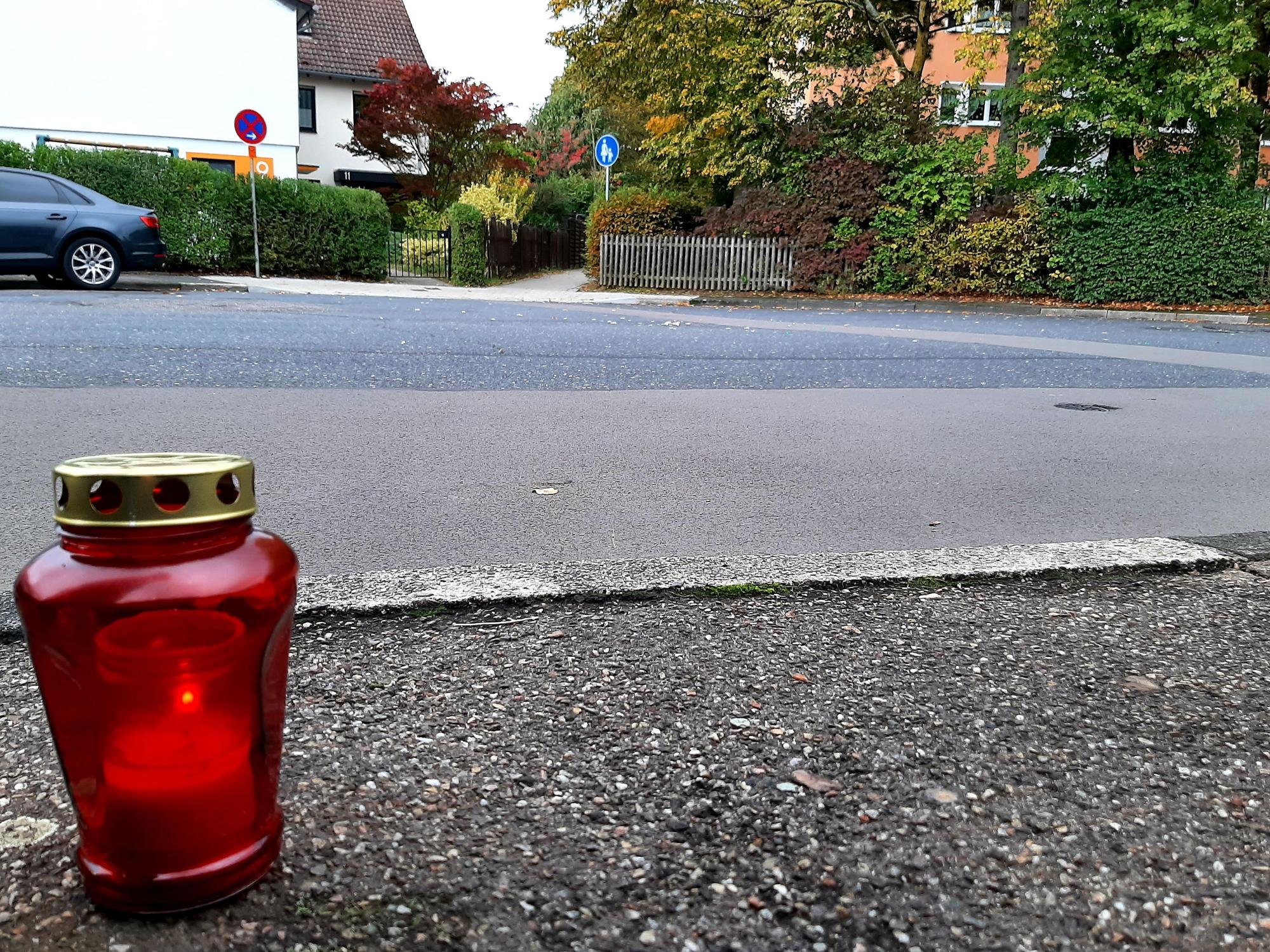Ein Grablicht steht auf dem Bürgersteig einer Straße.