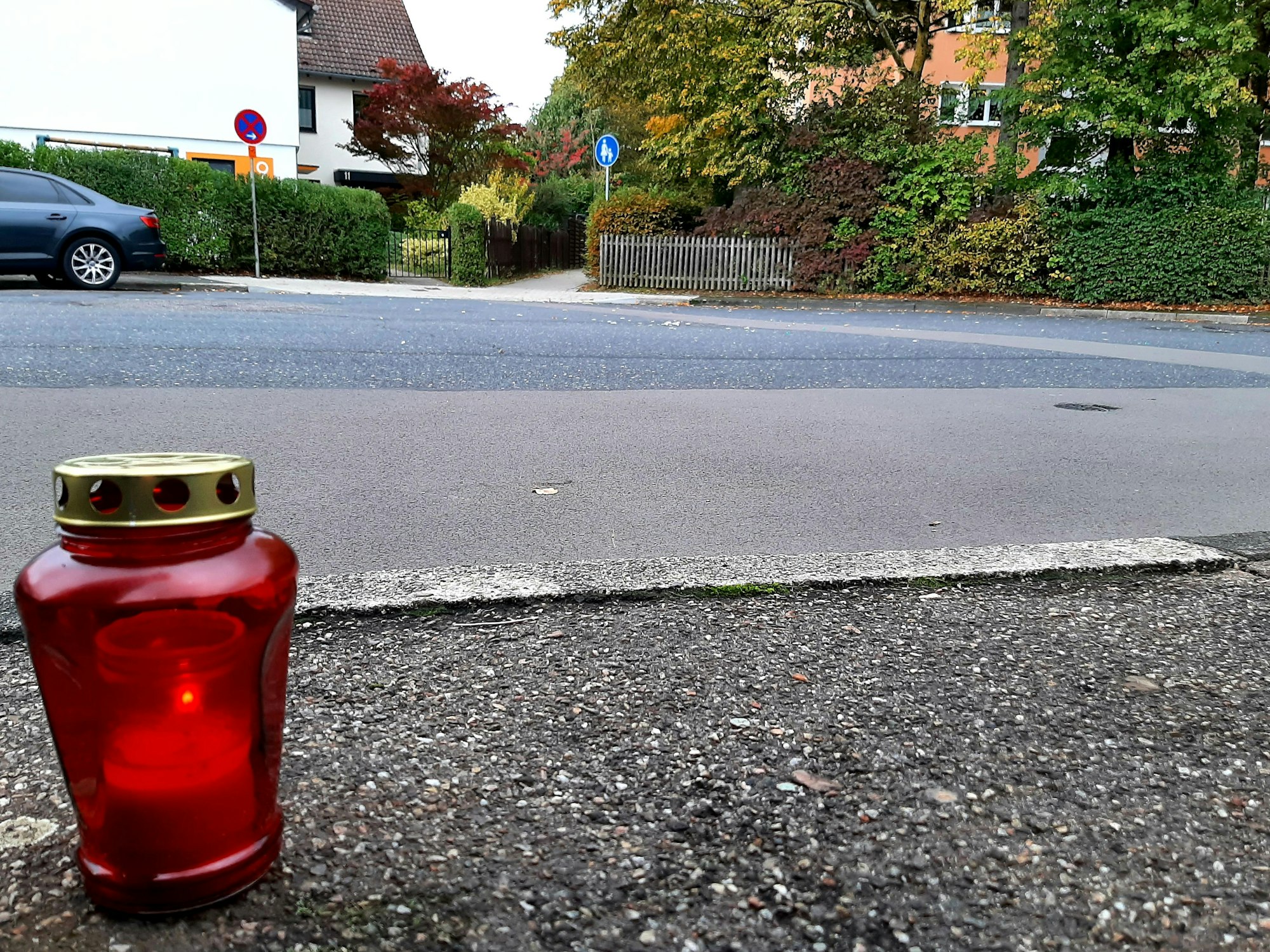 Ein Grablicht steht auf dem Bürgersteig einer Straße.