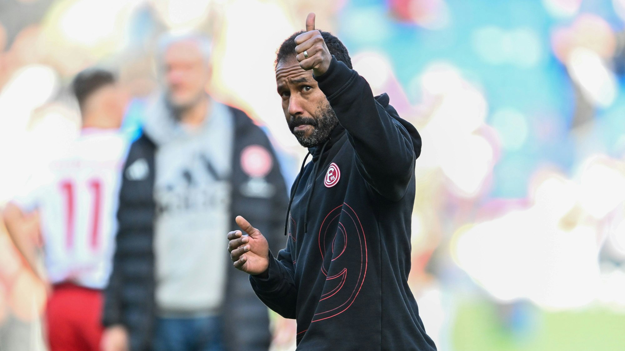 Fortuna Düsseldorfs Trainer Daniel Thioune hebt am Spielfeldrand den Daumen.
