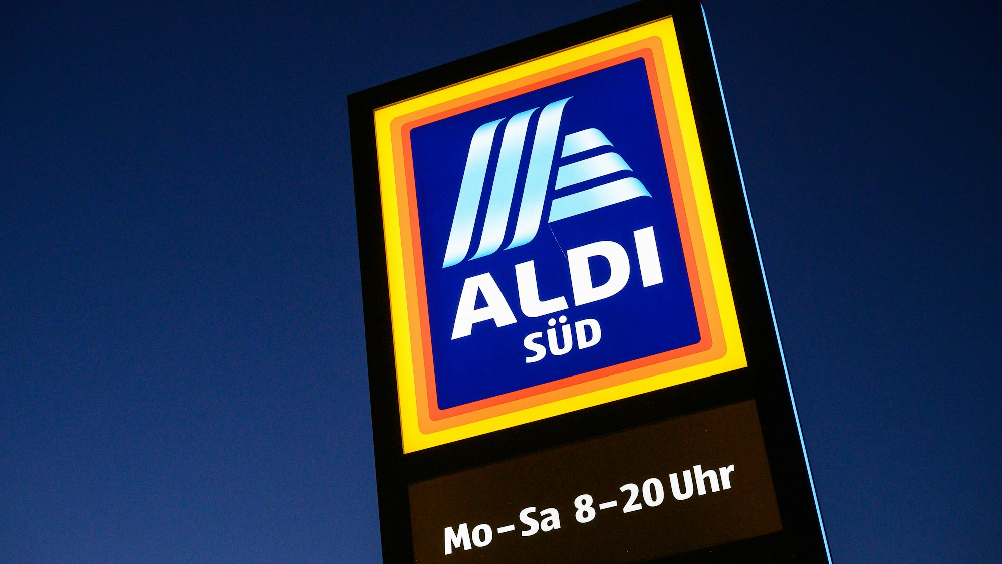 Ein Schild des Discounters Aldi Süd leuchtet.