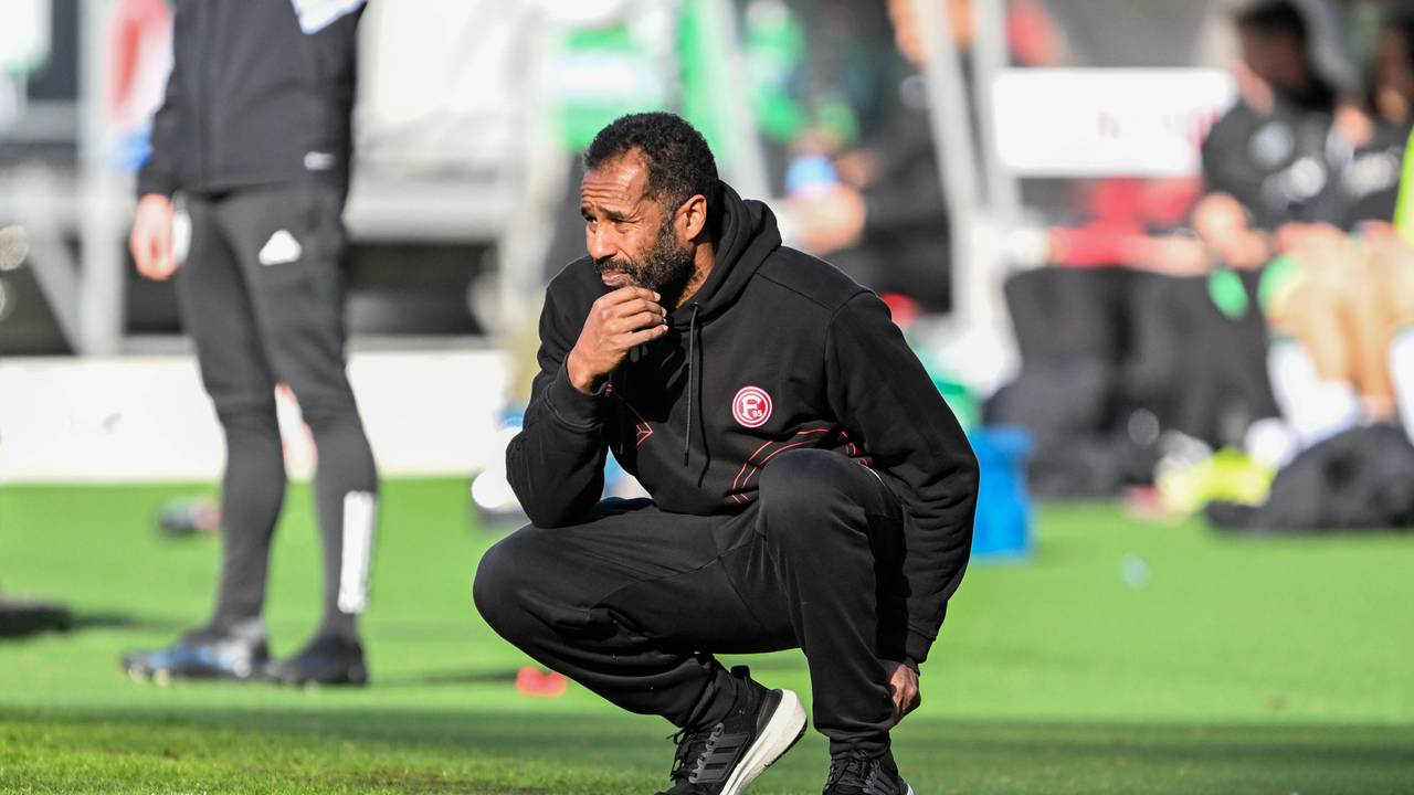 Daniel Thioune geht beim Spiel von Fortuna Düsseldorf nachdenklich in die Hocke.