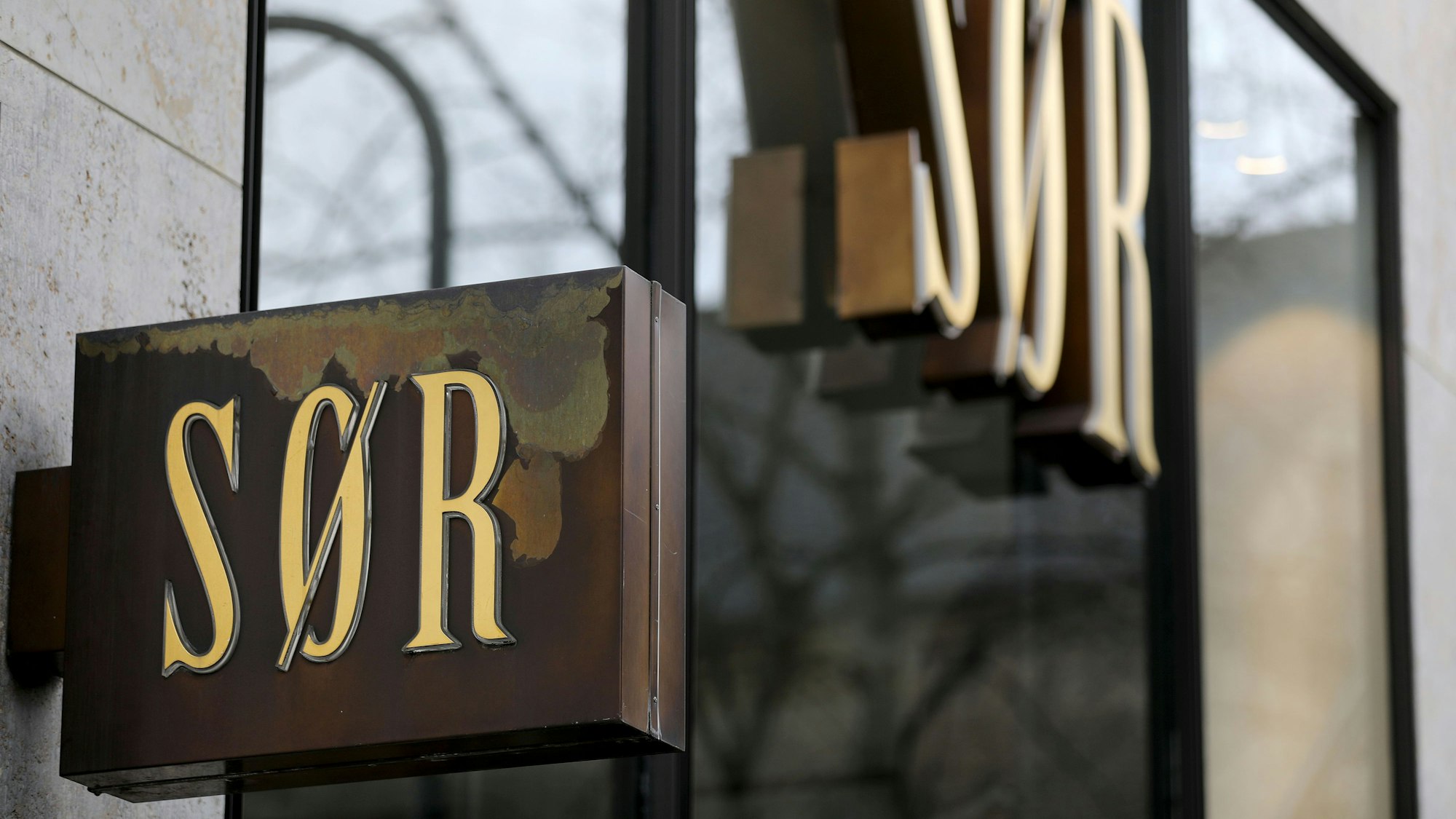 Logos der Modekette Sør hängen an einer Filiale in Köln.