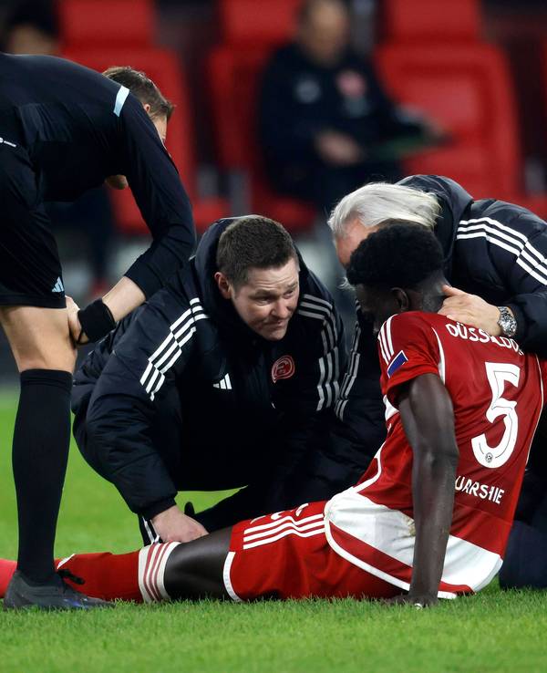 Fortuna Düsseldorfs Abwehrspieler Joshua Quarshie sitzt verletzt auf dem Platz und wird vom medizinischen Personal behandelt.
