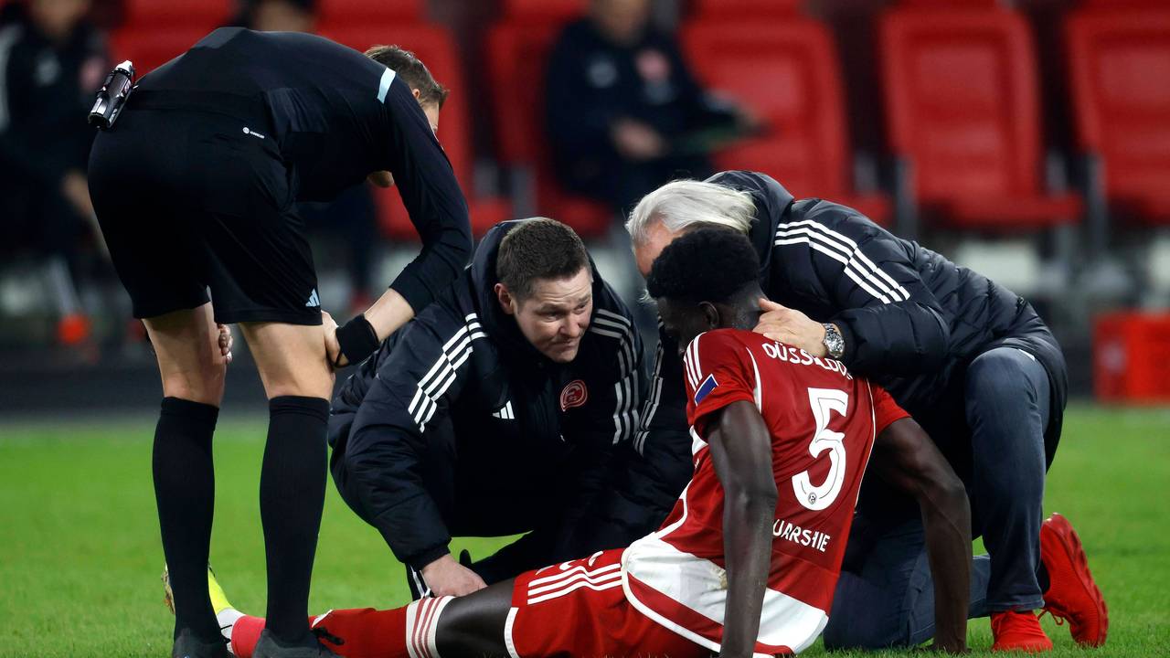 Fortuna Düsseldorfs Abwehrspieler Joshua Quarshie sitzt verletzt auf dem Platz und wird vom medizinischen Personal behandelt.