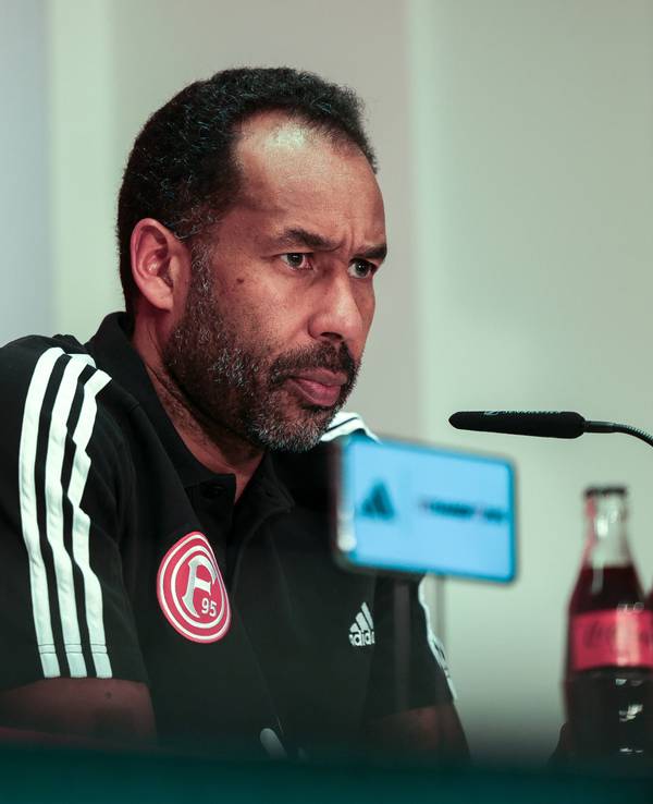 Fortuna Düsseldorfs Trainer Daniel Thioune sitzt bei der Pressekonferenz auf dem Podium.