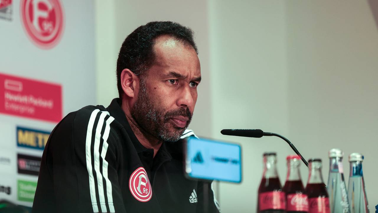 Fortuna Düsseldorfs Trainer Daniel Thioune sitzt bei der Pressekonferenz auf dem Podium.