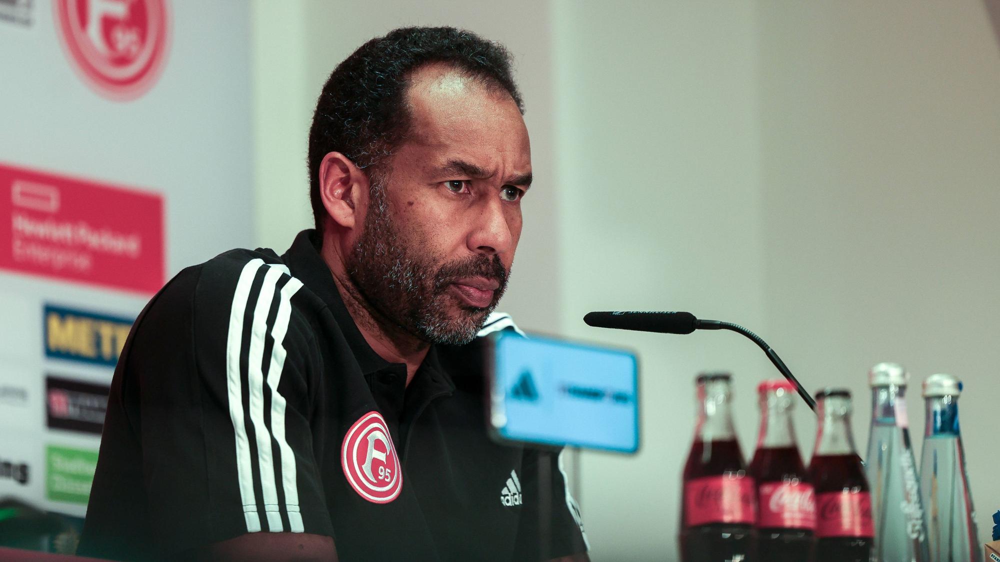 Fortuna Düsseldorfs Trainer Daniel Thioune sitzt bei der Pressekonferenz auf dem Podium.