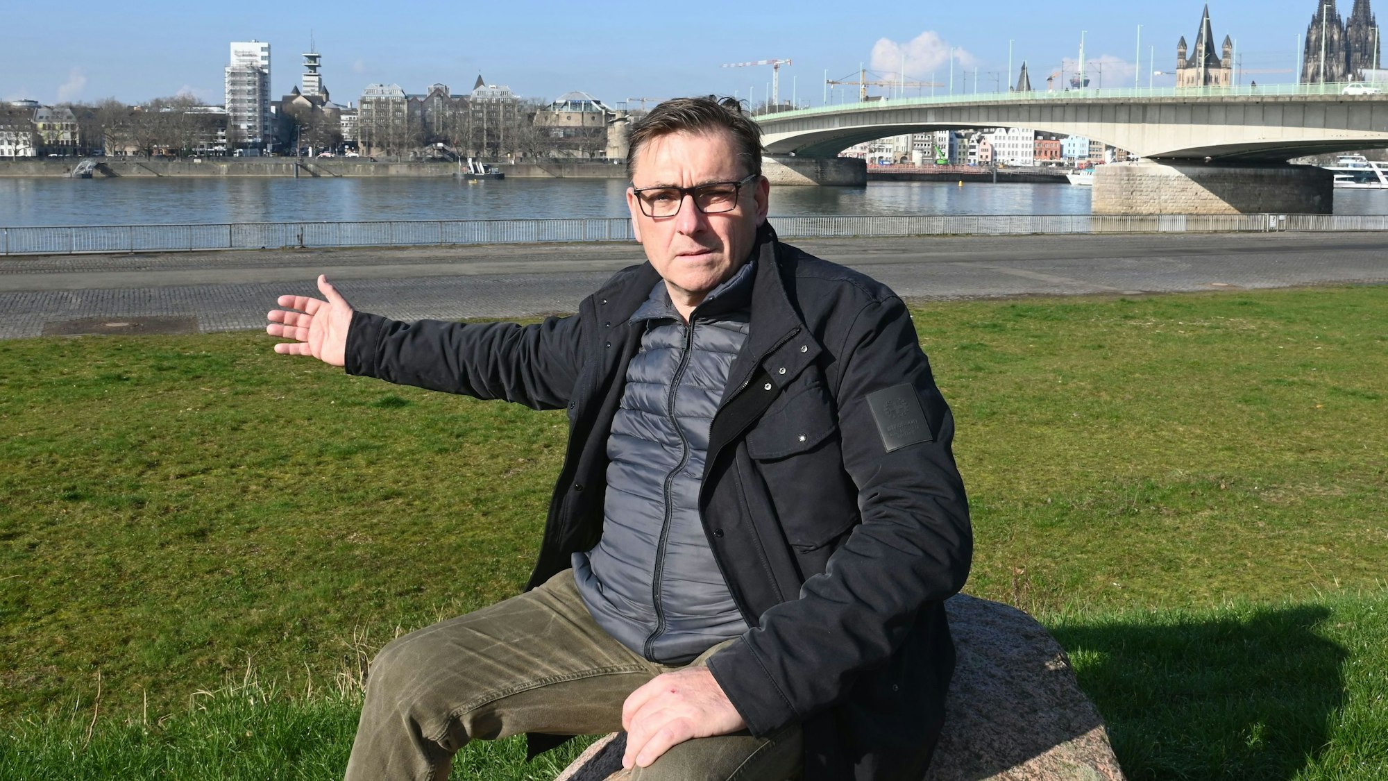 Veranstalter Wilfried Hoffmann sitzt am 6. März 2024 auf einem Stein an der Deutzer Werft.