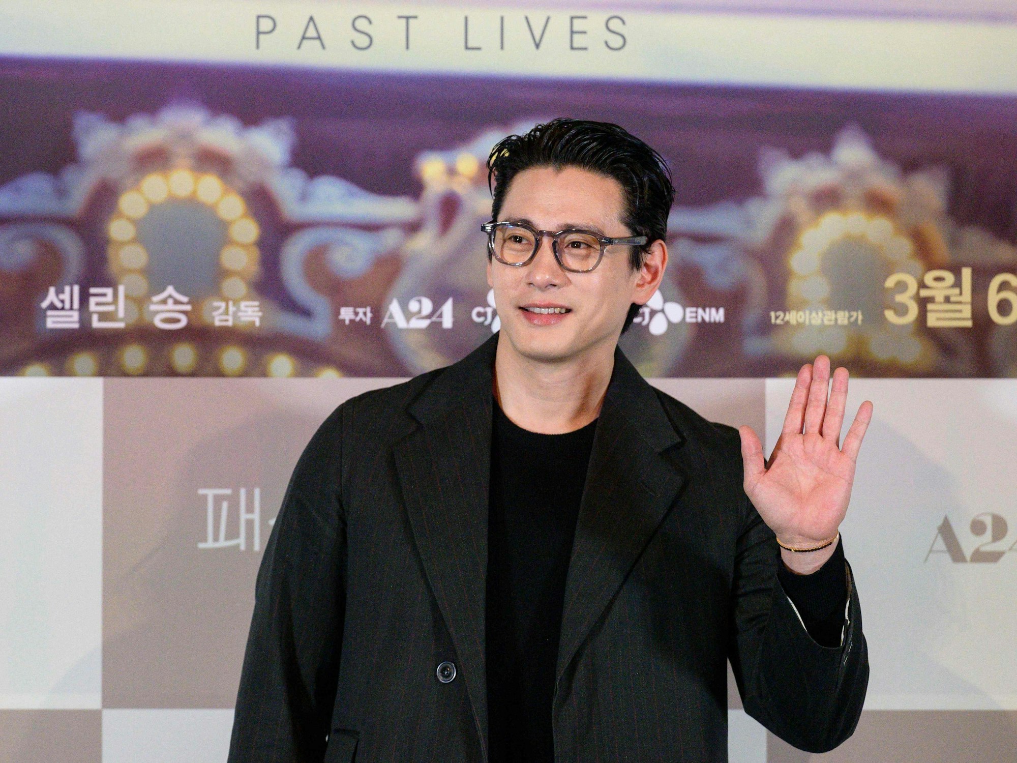 Teo Yoo winkt in die Kamera.