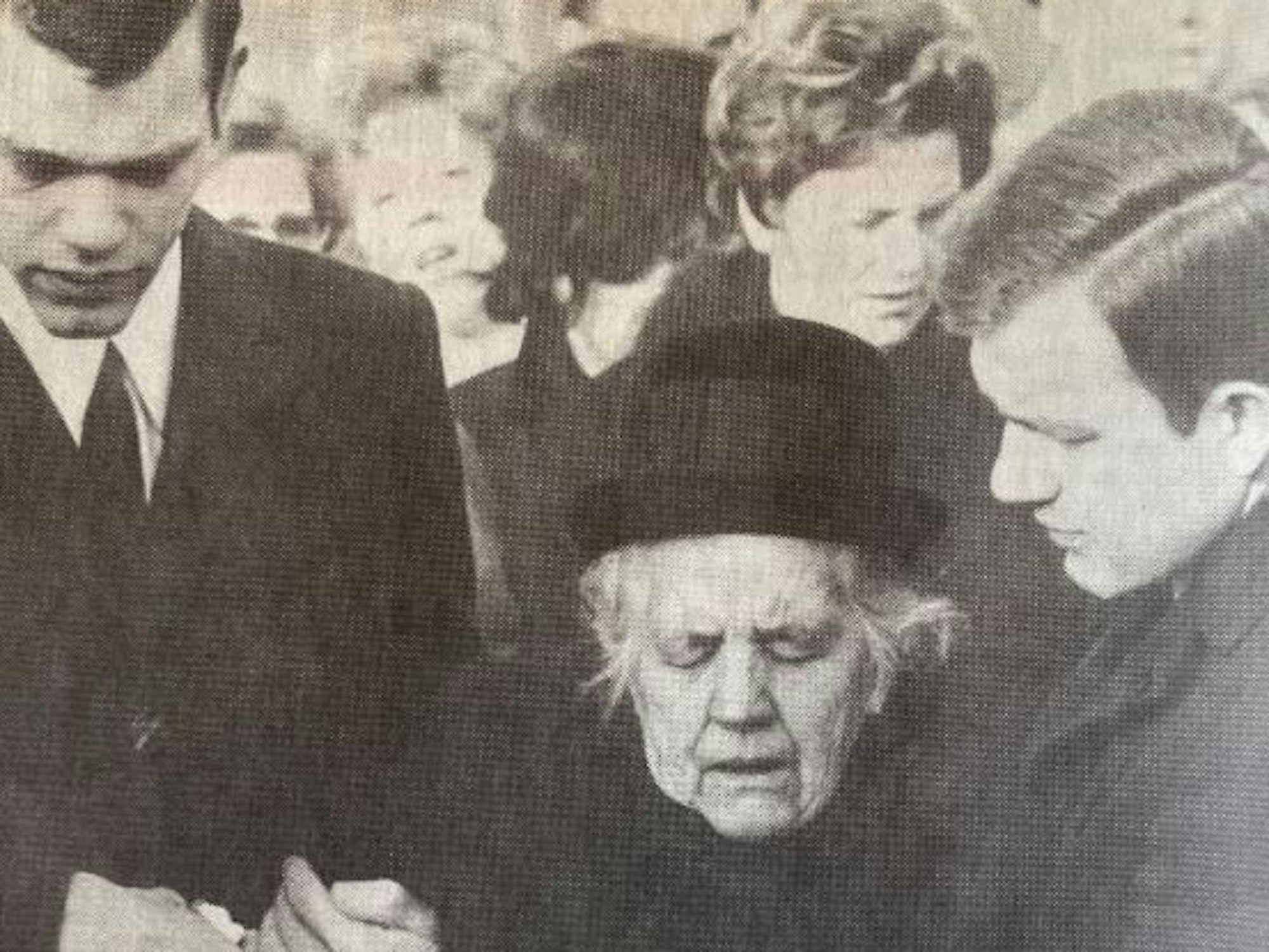 Dummse Tünn stützt seine Mutter bei einer Beerdigung.